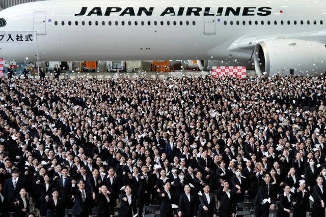 일본항공(JAL) 신입사원들이 지난해 4월 1일 도쿄 하네도공항 비행기 정비 격납고에서 열린 입사식에 참석해 종이비행기를 던지고 있다. 도쿄=EPA 연합뉴스