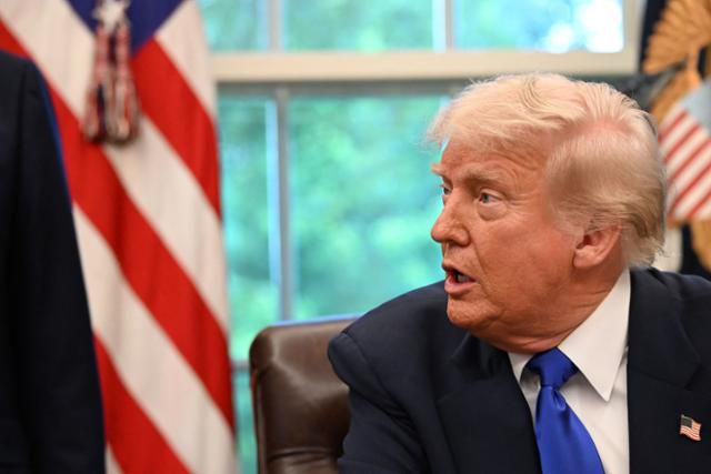 도널드 트럼프 미국 대통령이 5일 워싱턴 백악관 집무실(오벌오피스)에서 행정명령에 서명하며 취재진 질문에 대답하고 있다. 워싱턴=AFP 연합뉴스