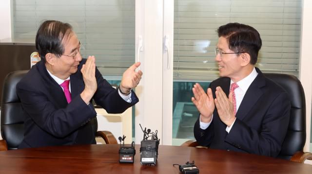 김문수(오른쪽) 국민의힘 대선 후보가 11일 서울 여의도 국민의힘 당사 내 대통령 후보실에서 한덕수 전 국무총리와 회동하며 박수 치고 있다. 공동취재사진 뉴시스