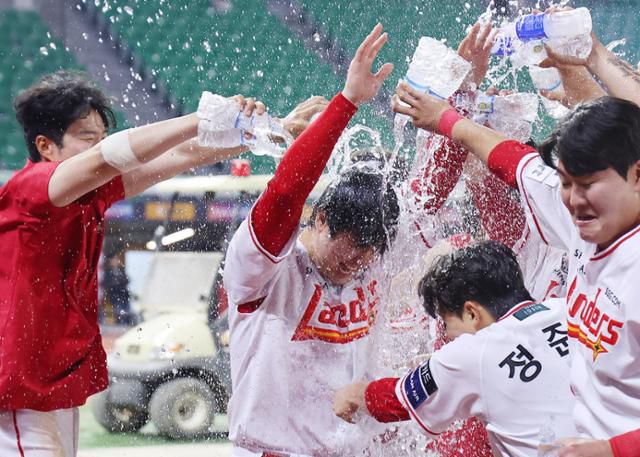 프로야구 역대 최초로 500홈런을 달성한 SSG 최정(가운데)이 13일 인천 SSG랜더스필드에서 열린 NC전에서 승리한 뒤 동료들에게 축하의 물세례를 받고 있다. 최정은 이날 6회말에 동점 2점포를 때려 통산 500홈런을 완성했다. 연합뉴스