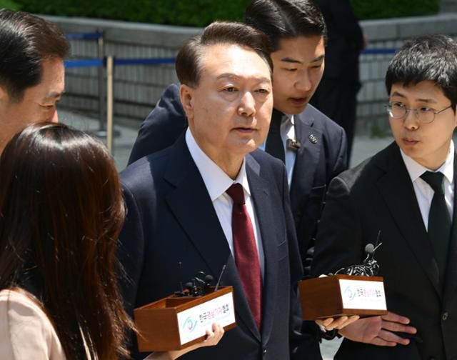 12·3 비상계엄 사태와 관련해 내란 우두머리 혐의로 기소된 윤석열(가운데) 전 대통령이 12일 서울 서초구 서울중앙지법에서 열린 3차 공판을 마친 뒤 법원 청사를 나서고 있다. 사진공동취재단