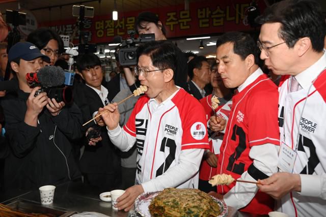 김문수(가운데) 국민의힘 대선후보가 14일 경남 진주시 진주중앙시장에서 어묵을 먹고 있다. 하상윤 기자