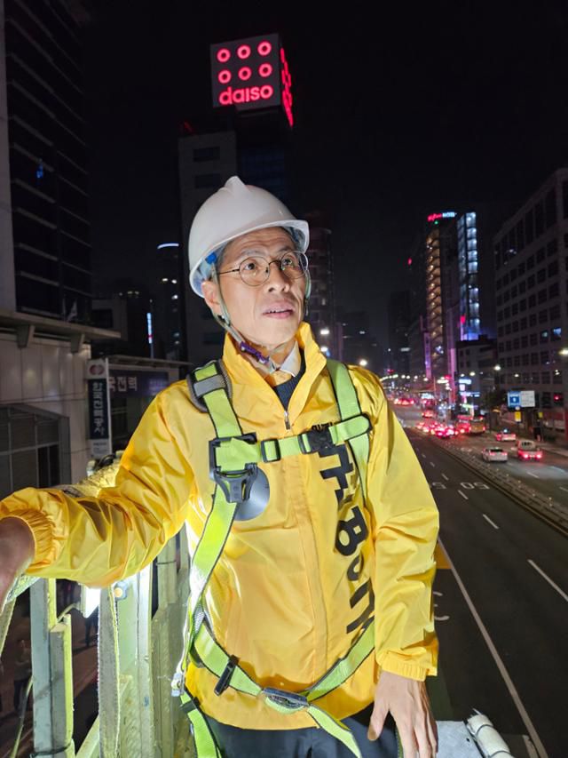 권영국 민주노동당 대통령 후보가 12일 새벽 서울 중구 세종호텔 앞에서 고공농성 중인 고진수 지부장을 만나기 위해 사다리차에 탑승해 있다. 뉴스1