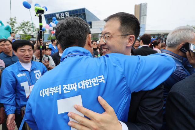 김상욱(오른쪽) 무소속 의원이 16일 전북 익산시 익산역 동부광장에서 열린 이재명 더불어민주당 대선 후보의 유세에 참석해 이춘석(가운데) 더불어민주당 의원과 포옹을 하고 있다. 익산=뉴스1