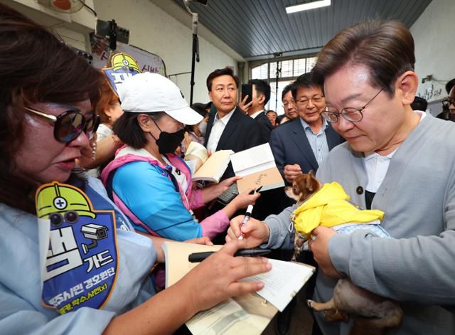 남도문화벨트 골목골목 경청투어에 나선 이재명 더불어민주당 대선 후보가 11일 전남 강진군 강진읍 강진오감통시장을 찾아 한 지지자의 반려견을 품에 안고 인사를 하고 있다. 연합뉴스