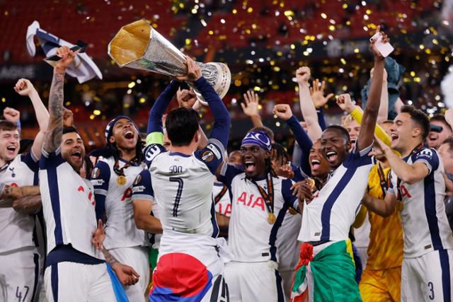 토트넘의 손흥민(가운데)이 22일(한국시간) 스페인 빌바오의 산 마메스 경기장에서 열린 맨체스터 유나이티드와 2024~25시즌 유럽축구연맹(UEFA) 유로파리그(UEL) 결승전에서 승리한 뒤 우승 트로피를 들고 동료들과 세리머니를 하고 있다. 빌바오=로이터 연합뉴스
