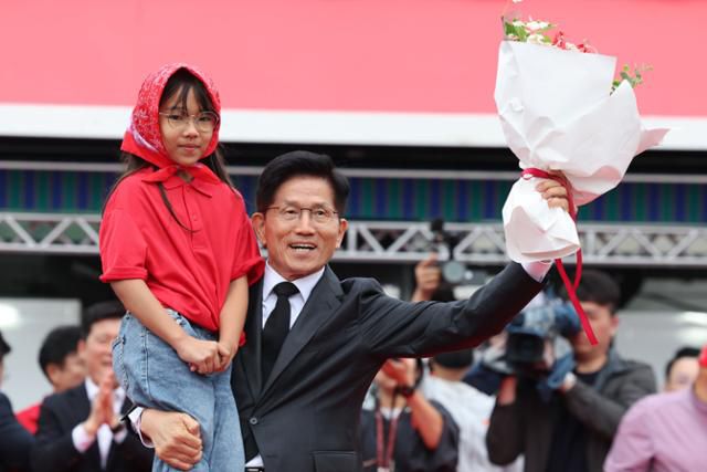 김문수 국민의힘 대선 후보가 24일 경북 구미시 박정희 전 대통령 생가 인근에서 열린 유세에서 꽃다발을 선물받은 뒤 기념촬영을 하고 있다. 구미=뉴시스