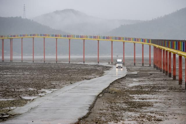 우도의 노둣길로 화물 차량이 지나고 있다. 뒤로 보이는 것이 새로 놓인 보행교.