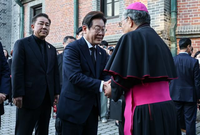 이재명 더불어민주당 대선 후보가 경선 후보 시절인 지난달 23일 서울 중구 명동대성당에 마련된 프란치스코 교황 빈소를 찾아 조문하기 전 천주교 서울대교구 총대리 구요비 주교와 인사하고 있다. 연합뉴스