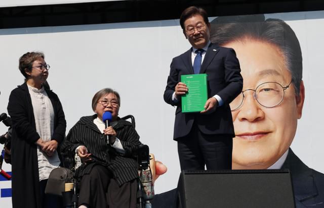 21대 대선 공식 선거운동이 시작된 지난 12일 이재명 더불어민주당 후보가 서울 청계광장에서 열린 '빛의 혁명' 광화문 유세에서 박김영희씨로부터 '모두의 질문 Q 녹서'를 전달받고 있다. 고영권 기자