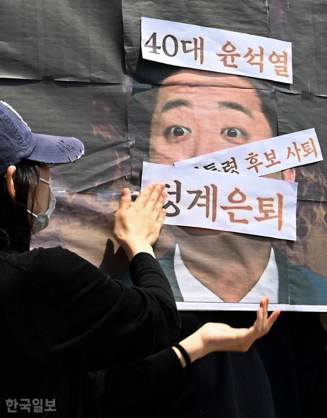 29일 서울 영등포구 개혁신당 당사 앞에서 열린 이준석 대통령 선거 후보 사퇴 촉구 기자회견에서 주최 측인 한국대학생진보연합이 이 후보 사진에 비판 문구를 붙이는 퍼포먼스를 하고 있다. 강예진 기자
