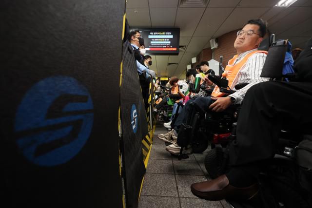 전국장애인차별천폐연대 회원들이 지난 13일 오후 서울 종로구 시청역 2호선 승강장에서 오세훈 서울시장에게 대화를 촉구하는 집회를 열고 서울교통공사 직원들과 대치하고 있다. 뉴시스