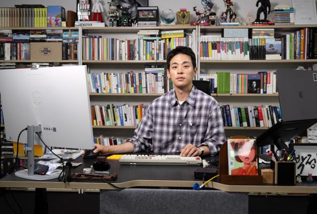 배우 박정민이 하루 중 가장 오랜 시간을 보내는 출판사 '무제'에서 그가 좋아하는 책들로만 가득 채운 책장 앞에 앉아 있다. 박시몬 기자