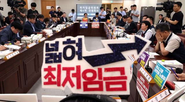 10일 세종시 정부세종청사에서 열린 최저임금위원회 4차 전원회의에서 한 근로자위원이 '넓혀 최저임금' 이라고 적힌 머리띠를 착용한 모습. 뉴시스