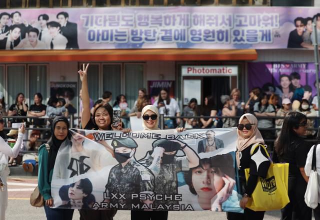 그룹 방탄소년단의 정국과 지민이 전역한 11일 서울 용산구 하이브 사옥 앞에서 방탄소녀단 팬덤인 아미들이 멤버들의 전역을 축하하고 있다. 뉴시스