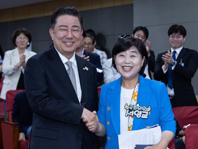 김병기(왼쪽)·서영교 더불어민주당 원내대표 후보가 10일 서울 여의도 국회 의원회관에서 열린 제22대 국회 민주당 제2기 원내대표 선출 합동토론회에서 만나 악수하고 있다. 뉴스1