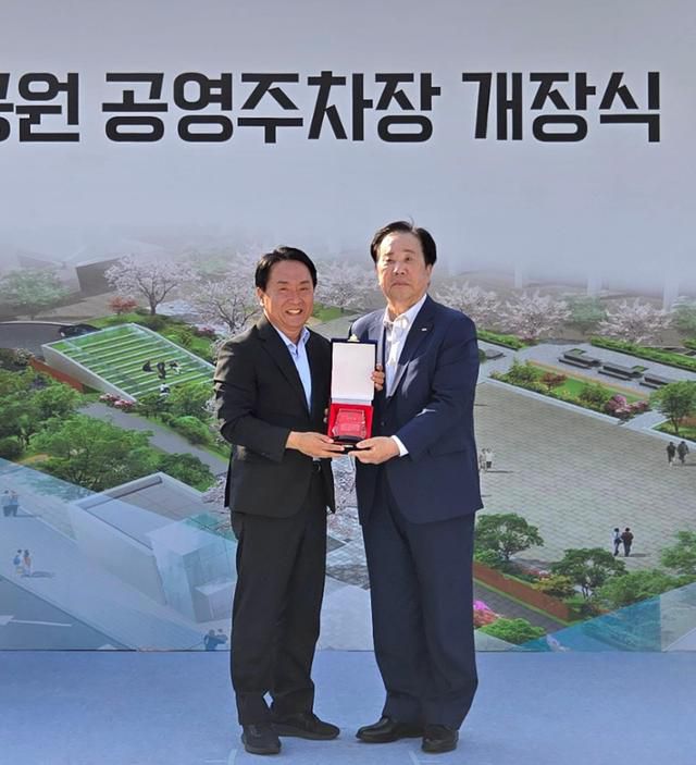 우오현(오른쪽) SM그룹 회장이 12일 서울 서대문구 독립문문화공원 공영주차장에서 이성헌 구청장으로부터 감사패를 받고 있다. SM그룹 제공