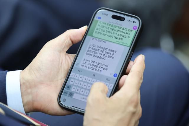 김민석 국무총리 후보자가 13일 서울 여의도 국회에서 열린 제2기 원내대표 선출 의원총회에 참석해 휴대폰으로 최근 의혹 관련 해명 글을 작성하고 있다. 뉴시스