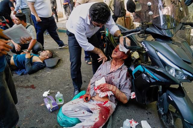 15일 이란 수도 테헤란에 이스라엘 공습에 피해를 입은 이들이 쓰러져 있다. 테헤란=AP 연합뉴스