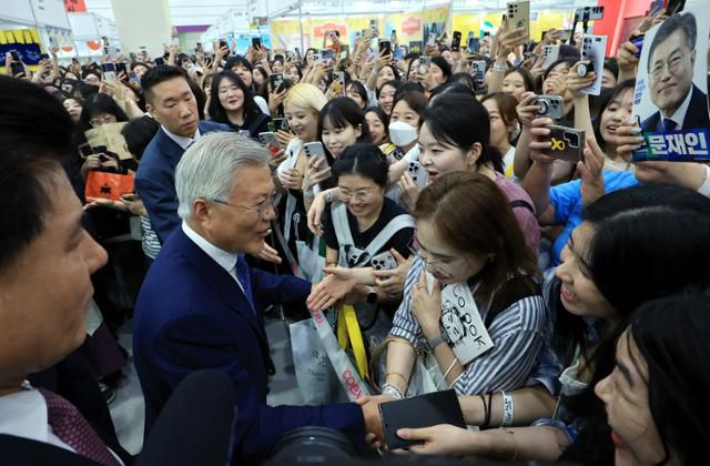 문재인 전 대통령과 부인 김정숙 여사가 18일 서울 강남구 삼성동 코엑스에서 열린 2025 서울국제도서전 평산책방 부스를 찾아 방문객들과 인사를 나누고 있다. 뉴스1