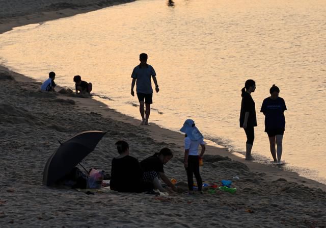 29일 강원도 강릉시 안목해변에서 시민들이 바닷물에 발을 담그거나 바닷바람을 맞으며 무더위를 식히고 있다. 강릉=연합뉴스