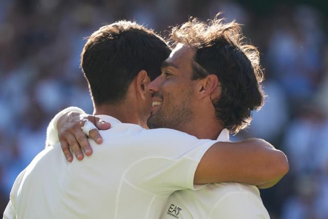6월 30일(현지시간) 영국 런던의 올잉글랜드 클럽에서 열린 2025 윔블던 1회전을 마친 카를로스 알카라스(왼쪽)과 파비오 포니니가 포옹하고 있다. 런던=AP 연합뉴스