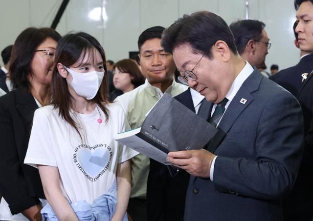이재명 대통령이 4일 대전 유성구 대전컨벤션센터에서 열린 국민소통 행보, 충청의 마음을 듣다 '충청의 꿈 다시 키우다'를 마치고 퇴장하며 한 참석자가 가져온 책에 사인을 해주고 있다. 왕태석 선임기자