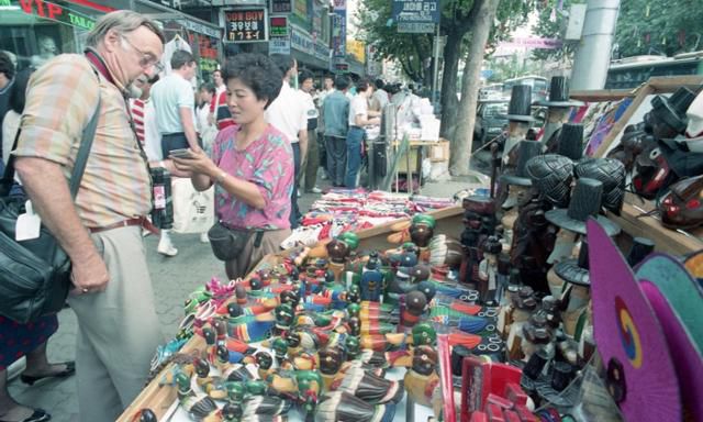 한 외국인이 1988년 서울올림픽 개최 당시 한국을 방문해 기념품을 고르고 있다. 한국일보 자료사진