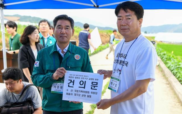 서흥원(왼쪽) 강원 양구군수가 3일 현장방문을 진행한 국정기획위원회에 동서고속화철도 양구 이촌·용하리 구간의 교각설치를 요구하는 건의문을 전달하고 있다. 양구군 제공