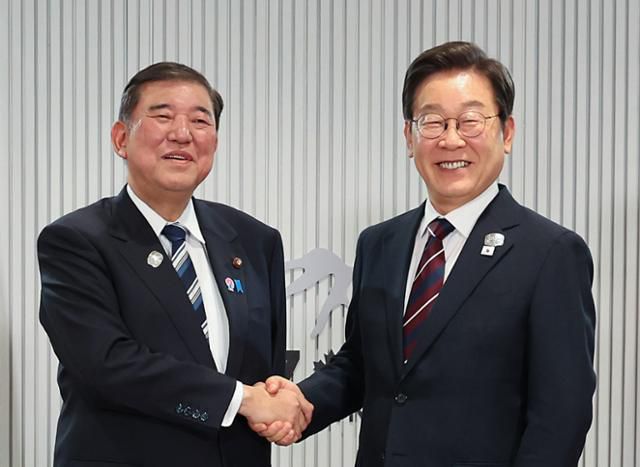 이재명 대통령이 17일(현지시간) 캐나다 앨버타주 캐내내스키스 주요 7개국(G7) 정상회의장에서 열린 한일 정상회담에서 이시바 시게루(왼쪽) 일본 총리와 악수하며 기념촬영을 하고 있다. 캐내내스키스=연합뉴스