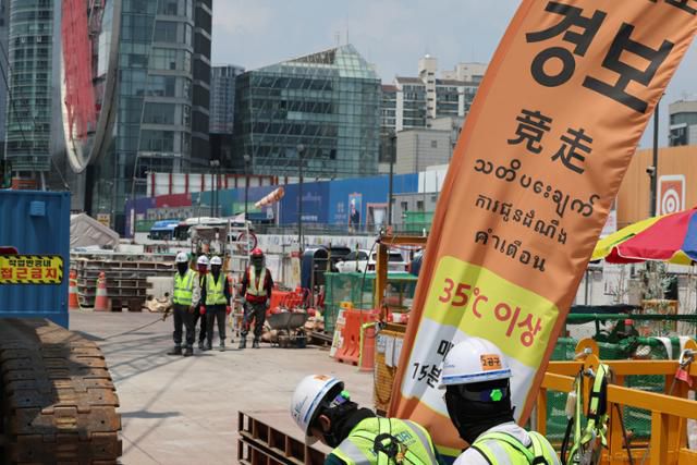 8일 폭염 경보가 발효 중인 서울 강남구 한 공사현장에 '체감온도 경보' 안내문이 설치돼 있다. 관계자는 근로자들이 45분 작업, 15분 휴식을 하고 있다고 밝혔다. 연합뉴스