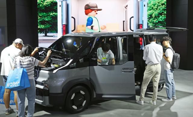 지난달 3일 서울 강남구 코엑스에서 열린 EV트렌드코리아 2025 행사 방문객들이 전시 차량을 구경하고 있다. 뉴스1