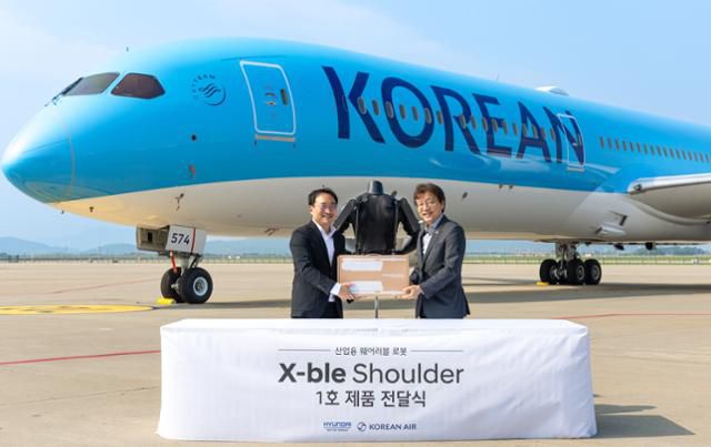 현동진(왼쪽) 현대차∙기아 로보틱스랩 상무와 정현보 대한항공 항공우주사업본부 상무가 8일 인천 중구 대한항공 항공기 정비고에서 '엑스블 숄더' 1호 전달식 후 기념 사진을 촬영하고 있다. 현대차·기아 제공