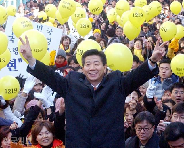 2002년 대선 당시 노무현(가운데) 민주당 후보가 강원 원주시장에서 열린 거리 유세에 참석해 지지자들 환호에 화답하고 있다. '노무현을 사랑하는 모임'(노사모) 회원들이 노란 풍선을 흔들며 노 후보 옆을 지키고 있다. 한국일보 자료사진