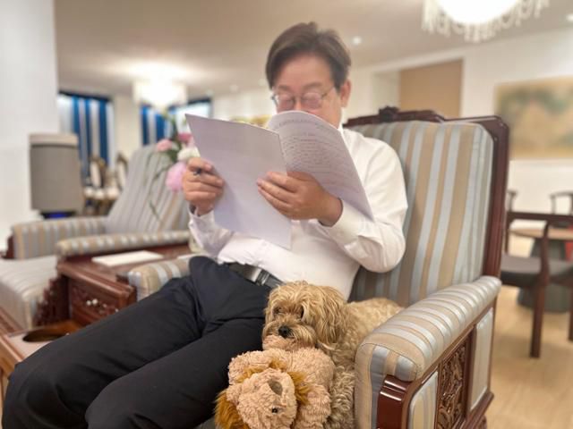 이재명 대통령이 반려견 '바비'를 곁에 둔 채 의자에 앉아 서류를 읽고 있다. 14일 이 대통령 엑스(X)에 게시한 사진이다. 이 대통령 X 계정 캡처
