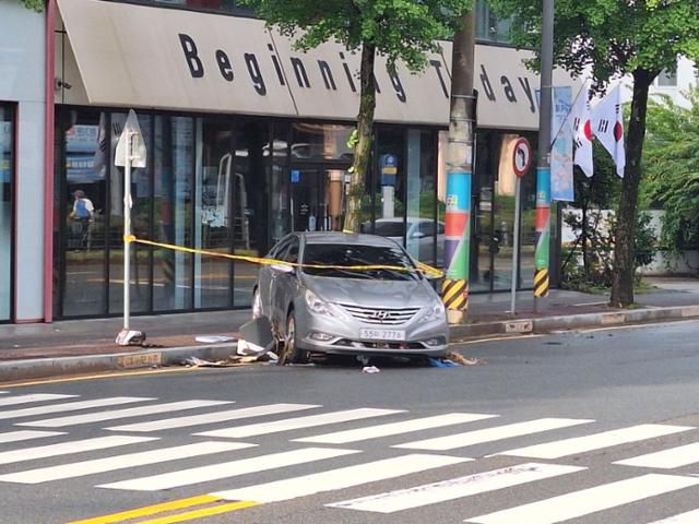 18일 오전 광주 북구 용봉동의 한 상가 앞 보도 턱에 전날 극한 호우에 휩쓸려 떠내려온 승용차가 절반쯤 걸쳐 있다.