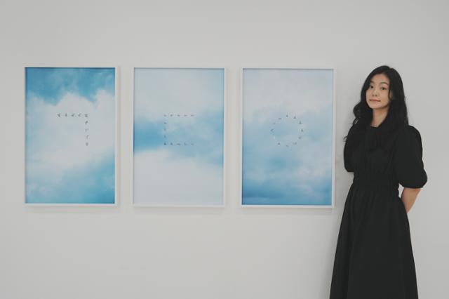 문선희 작가가 광주 양림미술관에서 열린 사진전 '친애하는 구구씨'에서 작품을 배경으로 사진 촬영을 하고 있다. 문선희 작가 제공