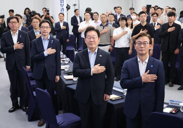 이재명 대통령이 25일 부산 부경대에서 열린 타운홀미팅 '부산의 마음을 듣다' 간담회에서 국기에 경례하고 있다. 앞줄 오른쪽부터 전재수 해양수산부 장관, 이 대통령, 김경수 대통령 직속 지방시대위원장, 박형준 부산시장. 연합뉴스