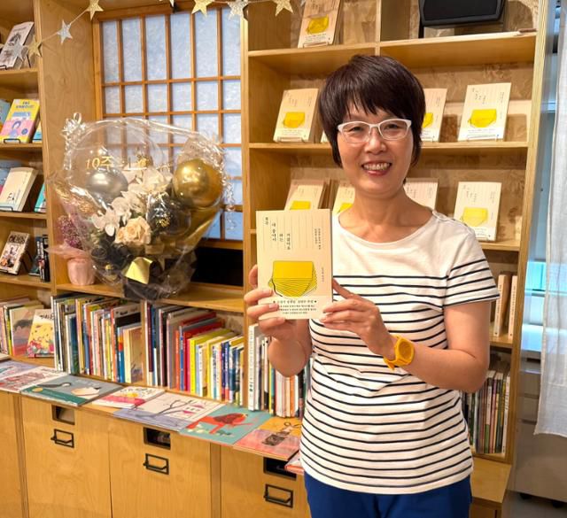 일본 도쿄에서 한국어 전문 책방 '책거리'를 운영하는 김승복 대표가 자신의 책 '결국 다 좋아서 하는 거잖아요'를 들고 미소 짓고 있다. 김승복 대표 제공