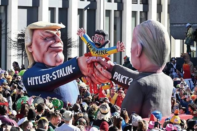 3월 독일 뒤셀도르프에서 열린 카니발에 도널드 트럼프(왼쪽) 미국 대통령과 블라디미르 푸틴 러시아 대통령이 손을 잡으며 볼로디미르 젤렌스키 우크라이나 대통령을 압살하는 모형이 등장했다. 뒤셀도르프= AFP 뉴시스