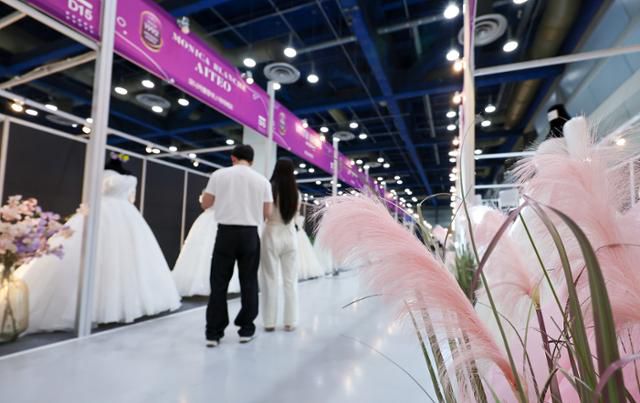 7월 6일 서울 강남구 삼성동 코엑스에서 열린 2025 추계 웨덱스 웨딩 박람회에서 예비부부가 드레스를 살펴보고 있다. 사진은 기사와 직접 관련이 없다. 뉴스1