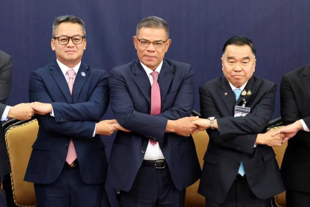 나타폰 나크파닛(왼쪽) 태국 국방 장관과 사이푸딘 나수티온 이스마일(가운데) 말레이시아 내무장관, 티 세이하 캄보디아 국방장관이 7일 말레이시아 쿠알라룸푸르에서 태국과 캄보디아 간 국경 분쟁을 논의하기에 앞서 사진 촬영을 하고 있다. 쿠알라룸푸르=로이터 연합뉴스