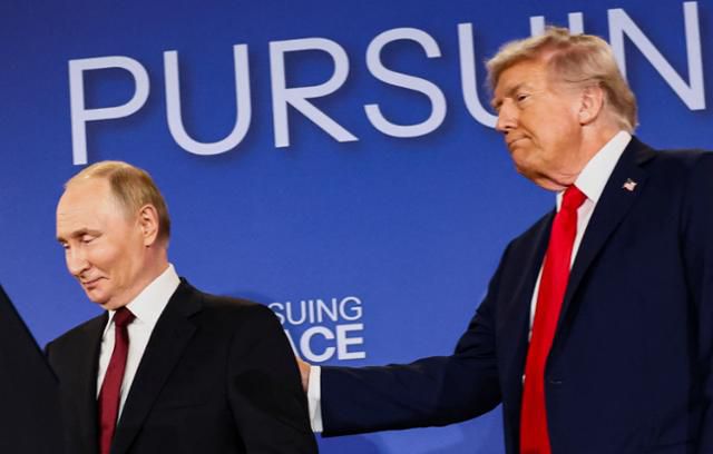 도널드 트럼프(오른쪽) 미국 대통령이 15일 미 알래스카주 앵커리지 엘먼도프-리처드슨 합동기지에서 회담한 뒤 함께 공동 기자회견에 참석한 블라디미르 푸틴 러시아 대통령의 등에 손을 대고 있다. 앵커리지=로이터 연합뉴스