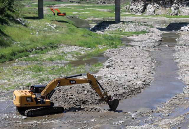 22일 강원 강릉시 주요 상수원인 오봉저수지 상류에서 굴착기가 동원돼 물의 원활한 유입을 위한 하상 정비가 긴급 시행되고 있다. 이 작업은 생활용수 확보를 위한 단기 대책으로 오봉저수지 상류 구간부터 도마2리까지 2.7km 구간을 폭 3m, 깊이 1.5m가량의 물길을 조성하는 것이다. 강릉=연합뉴스