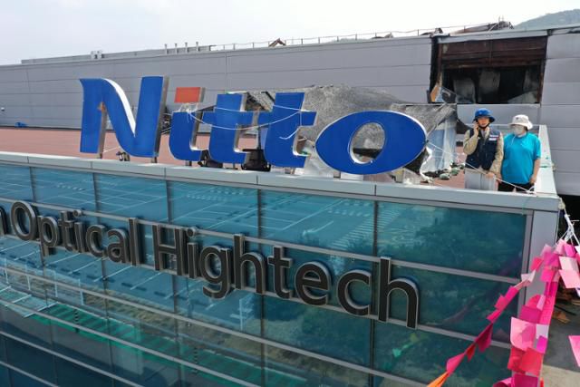 지난 4월 10일 경북 구미시 한국옵티칼하이테크 고공농성장에서 박정혜, 소현숙 노동자가 휴대전화로 건물 아래 한국일보 기자와 인터뷰를 하고 있다. 회사는 공장에 화재가 발생하자 생산 물량을 다른 자회사 공장으로 이전한 뒤 노동자들은 정리해고했다. 구미=홍인기 기자