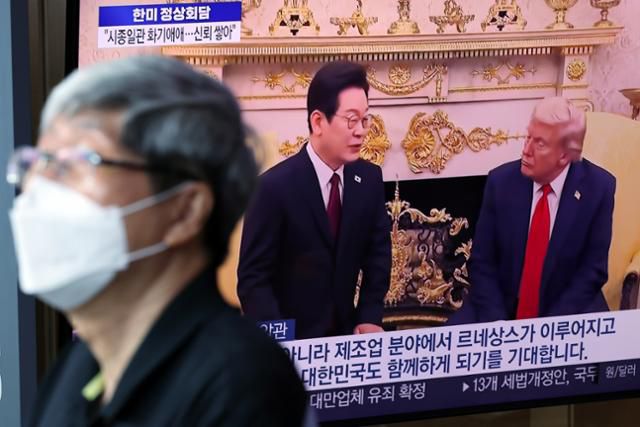 26일 오전 서울 용산구 서울역 대합실에서 시민들이 이재명 대통령과 도널드 트럼프 미국 대통령 간 한미 정상회담 관련 뉴스를 지켜보고 있다. 뉴스1