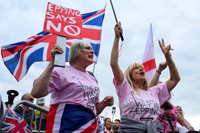 시위대가 24일 영국 에핑의 벨 호텔 밖에서 반(反)이민 시위에 참석하고 있다. 영국 정부가 망명 신청자에게 제공하는 이 호텔에는 얼마 전 14세 소녀를 성폭행한 에티오피아 출신 망명 신청자가 머물렀다. 에핑=로이터 연합뉴스