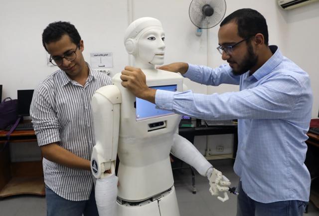 2021년 8월 11일 이집트 카이로에 있는 아인샴스대에서 엔지니어들이 로봇 간호사를 선보이고 있다. 이 로봇은 신종 코로나바이러스 감염증(코로나19) 확산 방지를 위해 환자와 의료진 간 영상통화를 가능하게 하는 등 직접 접촉을 줄일 목적으로 개발됐다. 카이로 EPA=연합뉴스