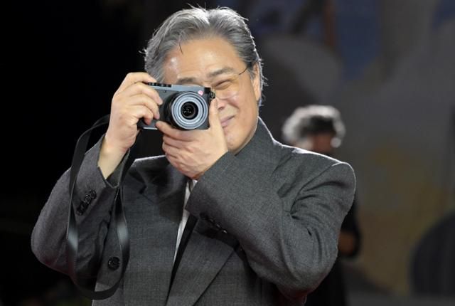 박찬욱 감독이 29일 이탈리아 베니스 리도섬의 살라 그란데에서 열린 제82회 베니스국제영화제 '어쩔수가없다' 공식 상영회를 앞두고 레드 카펫에서 카메라를 들고 사진을 찍는 포즈를 하고 있다. 베니스=EPA 연합뉴스