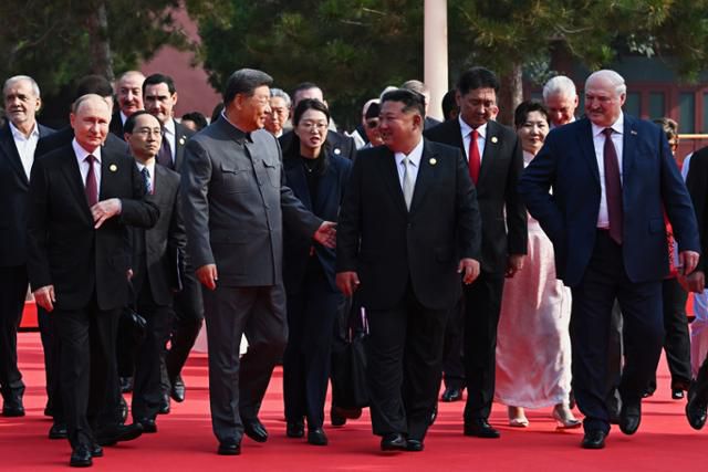 김정은 북한 국무위원장이 3일(현지 시간) 시진핑 중국 국가주석과 얘기하며 '중국 인민 항일 전쟁 및 세계 반파시스트 전쟁 승리(전승절)' 80주년 기념 열병식이 열리는 베이징 톈안먼 광장으로 걸어오고 있다. 베이징=AP 뉴시스